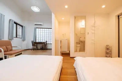 a room with two beds and a table at Hearty Stay Ikebukuro in Tokyo