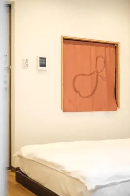 a bed in a room with a painting on the wall at Hearty Stay Ikebukuro in Tokyo