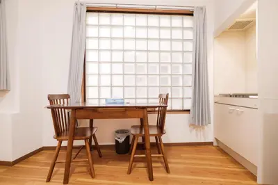a table and two chairs in a kitchen with a window at Hearty Stay Ikebukuro in Tokyo