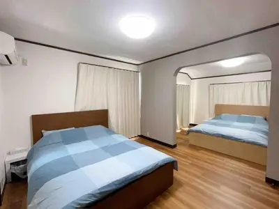 a bedroom with two beds and a mirror at \u4e1c\u4eac\u90fd\u5df4\u58eb\u76f4\u8fbe\u8fea\u65af\u5c3c\u4e50\u56ed Himawari \u53ef\u4f4f10\u4eba in Tokyo