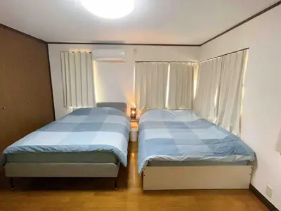two beds in a small room with two windows at \u4e1c\u4eac\u90fd\u5df4\u58eb\u76f4\u8fbe\u8fea\u65af\u5c3c\u4e50\u56ed Himawari \u53ef\u4f4f10\u4eba in Tokyo