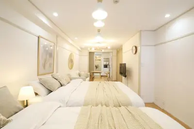 a bedroom with a large white bed and a couch at \u30aa\u30b0\u30e9\u30d3\u30eb 203 in Tokyo