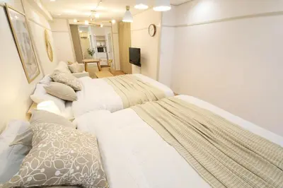 a bedroom with three beds and a living room at \u30aa\u30b0\u30e9\u30d3\u30eb 203 in Tokyo