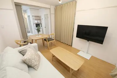 a living room with a couch and a flat screen tv at \u30aa\u30b0\u30e9\u30d3\u30eb 203 in Tokyo