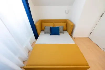 a yellow bed with two pillows on it in a room at \u7d50\u5eb5\u82b1\u9ce5 in Tokyo
