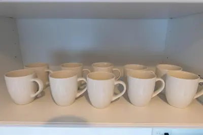 a row of coffee cups sitting on a shelf at \u7d50\u5eb5\u82b1\u9ce5 in Tokyo