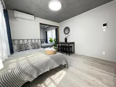 a bedroom with a bed and a table in it at Comma House Otsuka 102 in Tokyo