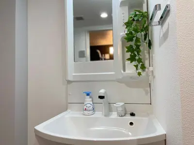 a white sink in a bathroom with a mirror at Comma House Otsuka 102 in Tokyo