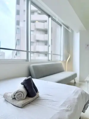 a hotel room with a bed with a towel on it at Terrace Tokyo Otsuka North in Tokyo