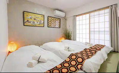 two beds in a room with white sheets at Cozy Room near Shinjuku Shibuya Ikebukuro in Tokyo