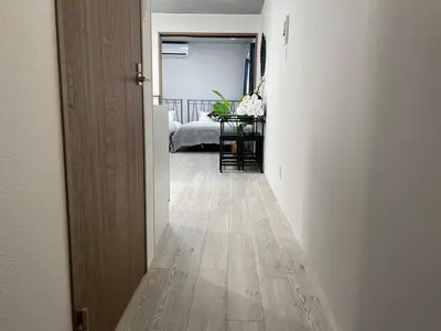 a hallway with a room with white walls and a wooden floor at Comma House Otsuka 3-2 in Tokyo