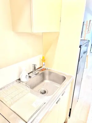 a sink in a small kitchen with a refrigerator at MIKASA guesthouse2 in Tokyo