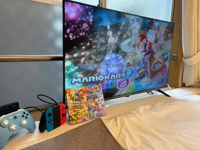 a tv screen with a video game and some games at Ikebukuro-Shinjuku-5min Zoshigaya Sta-Easy train access to Shinjuku and Shibuya in Tokyo