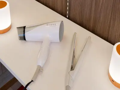 a hair dryer on a table next to some scissors at Ikebukuro-Shinjuku-5min Zoshigaya Sta-Easy train access to Shinjuku and Shibuya in Tokyo
