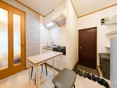 a small kitchen with a wooden table and chairs at Ikebukuro-Shinjuku-5min Zoshigaya Sta-Easy train access to Shinjuku and Shibuya in Tokyo