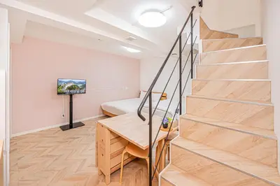 a room with a staircase with a bed and a television at Japan House Edogawabashi Retaw Hills Aprtment in Tokyo