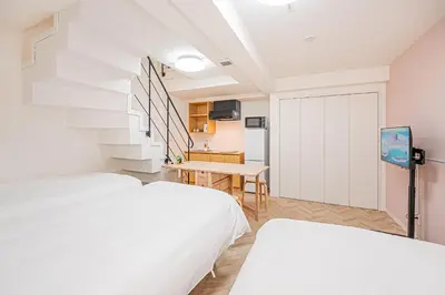 a bedroom with two beds and a staircase at Japan House Edogawabashi Retaw Hills Aprtment in Tokyo