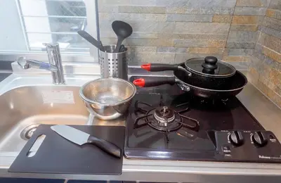 a stove top with a pot on it next to a sink at Flat K Plum Umegaoka by Tranova in Tokyo