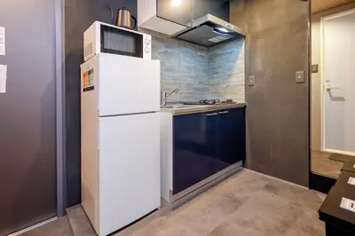 a kitchen with a white refrigerator and a sink at Flat K Plum Umegaoka by Tranova in Tokyo