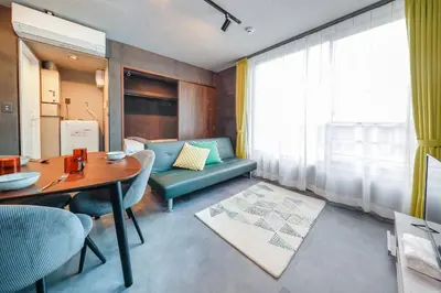 a living room with a blue couch and a table at Flat K Plum Umegaoka by Tranova in Tokyo