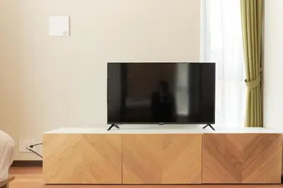 a flat screen tv sitting on top of a wooden entertainment center at Cure Azumabashi by Tranova in Tokyo