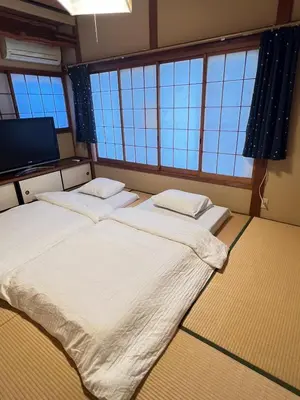 two beds in a room with large windows at \u5b9d\u5c45\u7acb\u77f3Hotel KS0433 in Tokyo