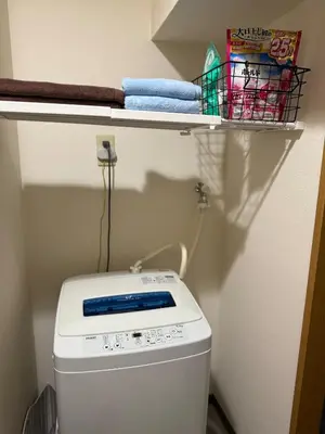 a washing machine in a bathroom with a shelf above it at Omori 8min Stylish and comfortable room in Tokyo