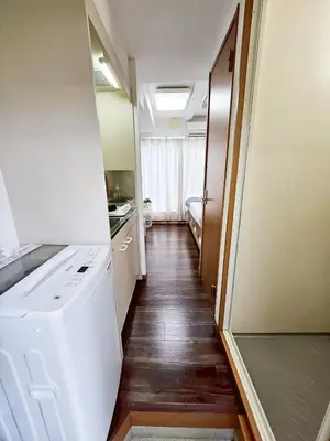a hallway of a kitchen with a washer and dryer at \u4e2d\u91ce\u30b7\u30a8\u30b9\u30bf\u30d7\u30ea\u30e0\u30e9 in Tokyo