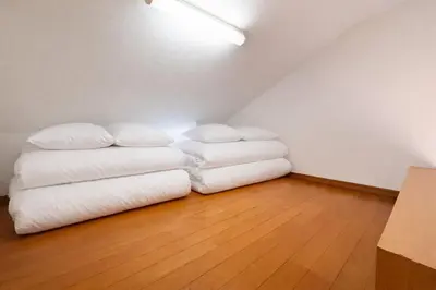 a room with two white pillows on a wooden floor at \u4e2d\u91ce\u30b7\u30a8\u30b9\u30bf\u30d7\u30ea\u30e0\u30e9 in Tokyo
