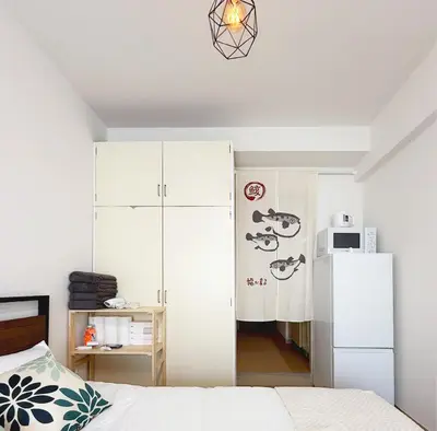a bedroom with a white refrigerator and a bed at The Vera in Tokyo