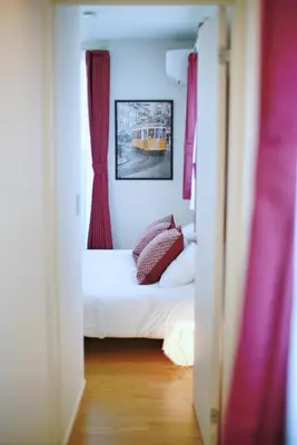a small bedroom with a bed and red curtains at SCD155 Spacious Villa in Ikebukuro Suburbs Direct Access to Tokyo's Core Commercial Districts in Tokyo