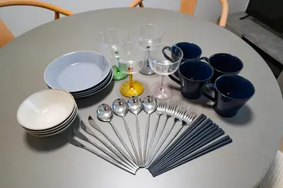 a table with plates and spoons and wine glasses at PRIME Asakusa by Tranova in Tokyo