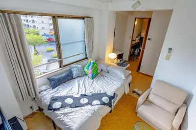 a bedroom with a bed and a window and a chair at welcome to shibuya ebisu in Tokyo