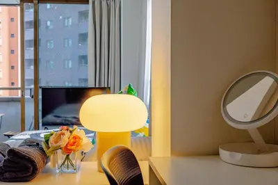 a table with a vase of flowers and a mirror at welcome to shibuya ebisu in Tokyo