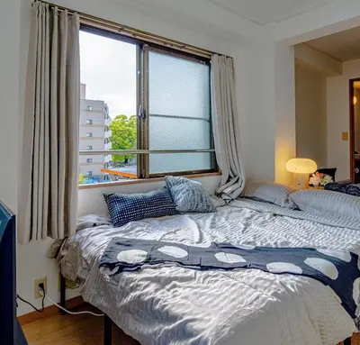 a bed in a bedroom with a large window at welcome to shibuya ebisu in Tokyo