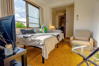 a bedroom with a bed and a tv and a window at welcome to shibuya ebisu in Tokyo