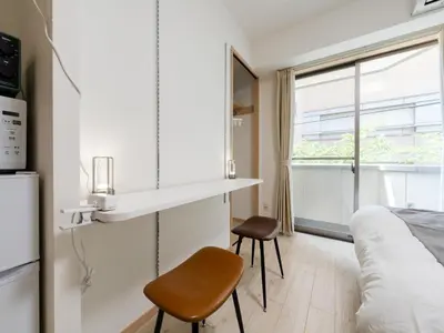 a small room with a bed and a table and chairs at Ikebukuro 10 min-Family-Friendly Stay-Mobile Wi-Fi&Switch-Net in Tokyo