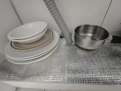 a stack of plates and a bowl on a metal shelf at \u6771\u4eac\u5929\u7a7a\u4e4b\u5bb6\u65c5\u9986101\u72ec\u7acb\u516c\u5bd3 \u72ec\u7acb\u536b\u6d74 in Tokyo