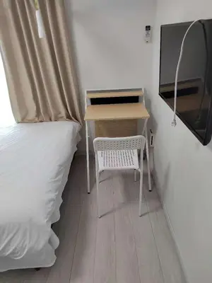 a small desk with a white chair next to a bed at \u6771\u4eac\u5929\u7a7a\u4e4b\u5bb6\u65c5\u9986101\u72ec\u7acb\u516c\u5bd3 \u72ec\u7acb\u536b\u6d74 in Tokyo