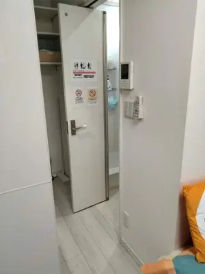 a white refrigerator in a room with a door at \u6771\u4eac\u5929\u7a7a\u4e4b\u5bb6\u65c5\u9986101\u72ec\u7acb\u516c\u5bd3 \u72ec\u7acb\u536b\u6d74 in Tokyo