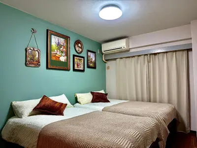 two beds in a room with green walls at G84 Shinjuku center 5 mins to Station, Max 3-\u65b0\u5bbf\u6700\u4e2d\u5fc3 \u6771\u65b0\u5bbf\u7ad95\u5206 \u76f4\u8fbe\u65b0\u5bbf \u6d89\u8c37 \u8868\u53c2\u9053 \u6c60\u888b \u4e0a\u91ce \u4ee3\u4ee3\u6728 \u94f6\u5ea7 \u539f\u5bbf in Tokyo