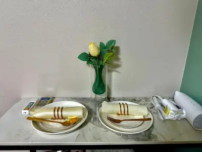 a table with two plates and a vase with a flower at G84 Shinjuku center 5 mins to Station, Max 3-\u65b0\u5bbf\u6700\u4e2d\u5fc3 \u6771\u65b0\u5bbf\u7ad95\u5206 \u76f4\u8fbe\u65b0\u5bbf \u6d89\u8c37 \u8868\u53c2\u9053 \u6c60\u888b \u4e0a\u91ce \u4ee3\u4ee3\u6728 \u94f6\u5ea7 \u539f\u5bbf in Tokyo