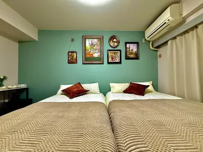 two beds sitting next to each other in a bedroom at G84 Shinjuku center 5 mins to Station, Max 3-\u65b0\u5bbf\u6700\u4e2d\u5fc3 \u6771\u65b0\u5bbf\u7ad95\u5206 \u76f4\u8fbe\u65b0\u5bbf \u6d89\u8c37 \u8868\u53c2\u9053 \u6c60\u888b \u4e0a\u91ce \u4ee3\u4ee3\u6728 \u94f6\u5ea7 \u539f\u5bbf in Tokyo