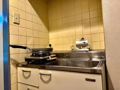 a kitchen with a sink and a pan on a stove at G84 Shinjuku center 5 mins to Station, Max 3-\u65b0\u5bbf\u6700\u4e2d\u5fc3 \u6771\u65b0\u5bbf\u7ad95\u5206 \u76f4\u8fbe\u65b0\u5bbf \u6d89\u8c37 \u8868\u53c2\u9053 \u6c60\u888b \u4e0a\u91ce \u4ee3\u4ee3\u6728 \u94f6\u5ea7 \u539f\u5bbf in Tokyo