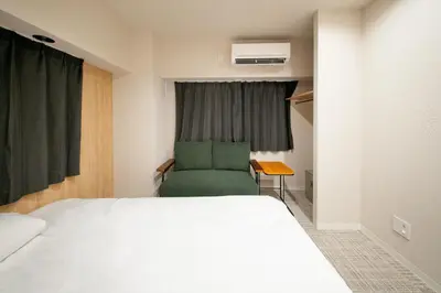 a bedroom with a bed and a chair in front of a window at Humming Kinshicho 303-202-301 - Vacation STAY 18969 in Tokyo