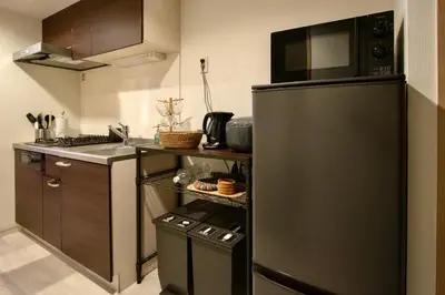 a kitchen with a black refrigerator and a sink at Generous Forest 101 in Tokyo