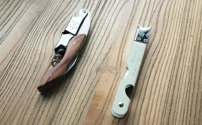 two knives sitting on a wooden table next to a gun at untio residence HATAGAYA North in Tokyo