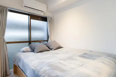 a bed with two pillows in a room with a window at untio residence HATAGAYA North in Tokyo