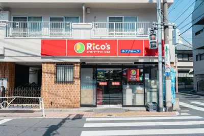a facade of a building with a riesgs store at untio residence HATAGAYA North in Tokyo