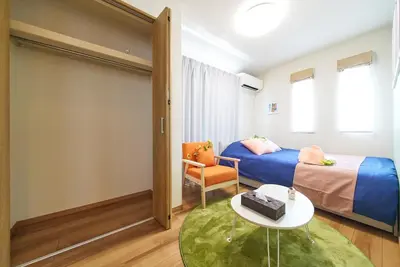 a bedroom with a bed and a table and a chair at Sumida A Cozy Entire House Sleeps 8 Near Station Tokyo Skytree Asakusa in Tokyo